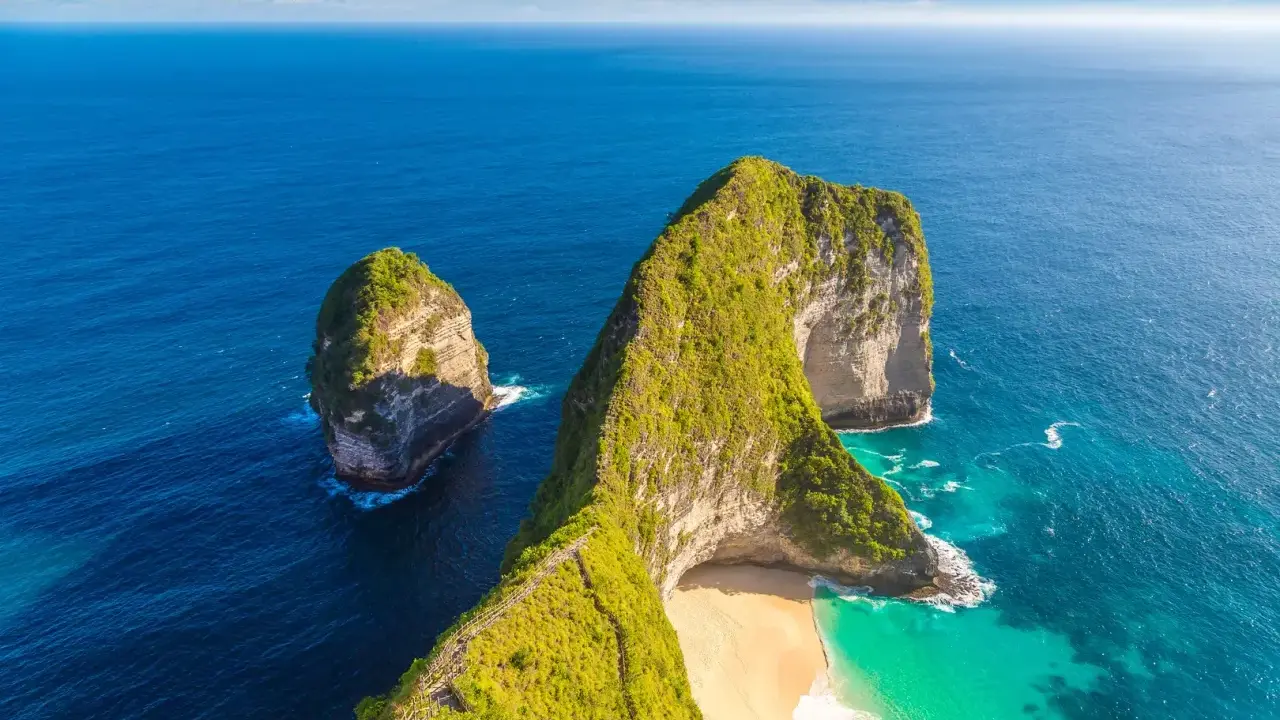 Nusa Penida, idealne miejsce na Twój **bali plan zwiedzania**. Klify porośnięte zielenią, turkusowa woda i piaszczysta plaża.