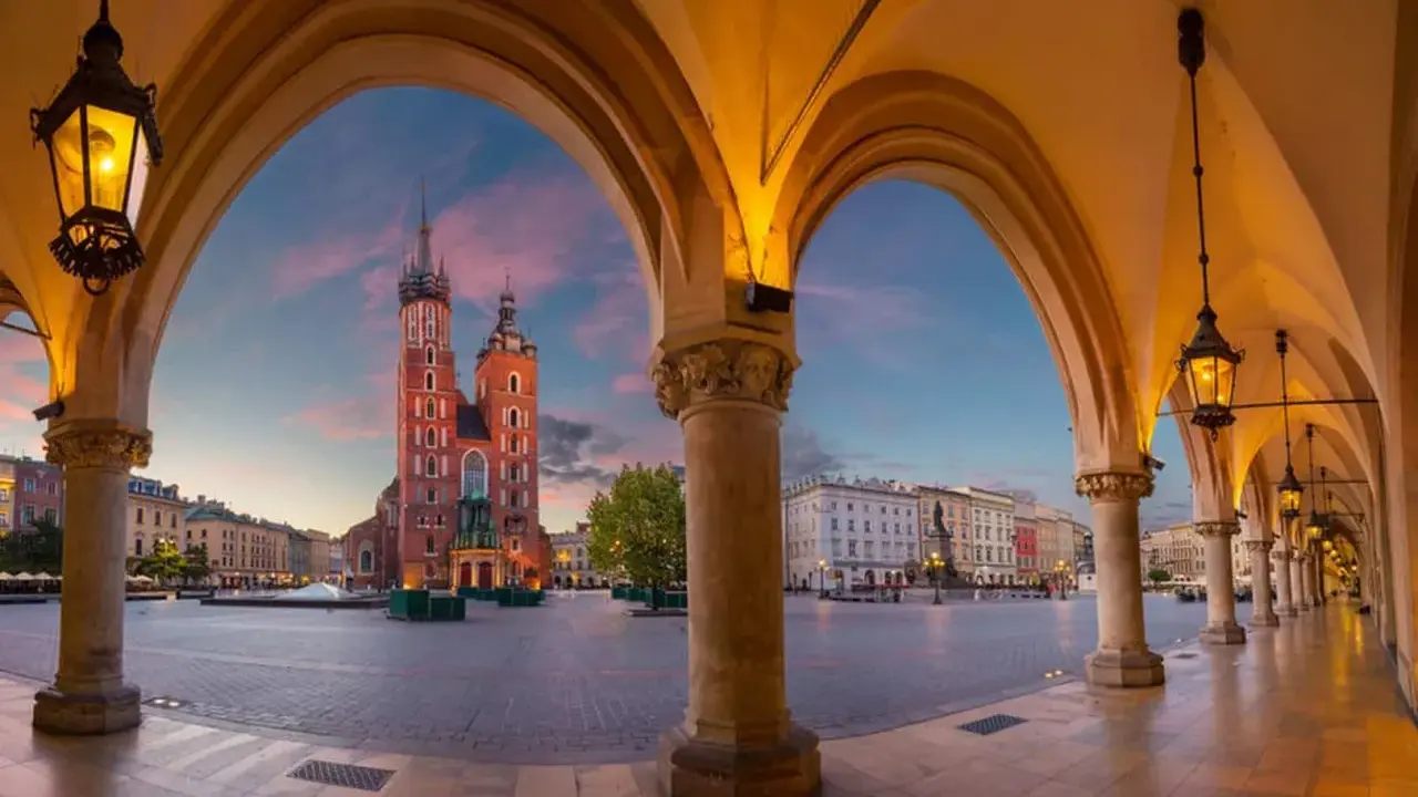 Kraków: Sukiennice i Kościół Mariacki o zachodzie słońca. Ciekawe ciekawostki o Krakowie czekają na odkrycie w tym magicznym miejscu.