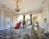 Elegancka klatka schodowa z czerwonym dywanem w Pałacu Branickich w Białymstoku. Sprawdź cennik zwiedzania!