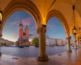Kraków: Sukiennice i Kościół Mariacki o zachodzie słońca. Ciekawe ciekawostki o Krakowie czekają na odkrycie w tym magicznym miejscu.