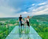 Rodzina cieszy się spacerem w chmurach w Szklarskiej Porębie. Szklany taras widokowy oferuje zapierający dech w piersiach widok na zielone wzgórza i miasteczko.