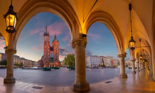 Kraków: Sukiennice i Kościół Mariacki o zachodzie słońca. Ciekawe ciekawostki o Krakowie czekają na odkrycie w tym magicznym miejscu.