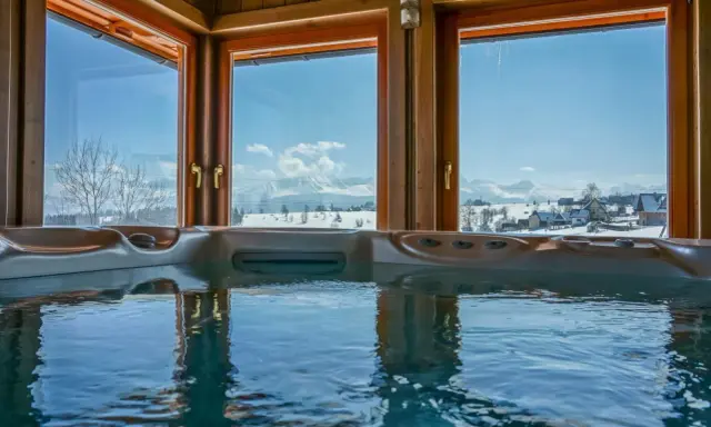 Gorąca wanna z widokiem na ośnieżone Tatry. Idealne zakopane atrakcje dla par na zimowy relaks.