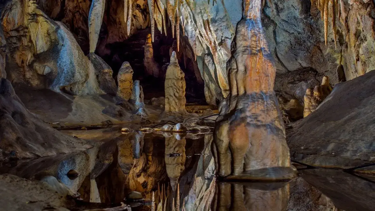 Wnętrze jaskini Raj z naciekami i stalagmitami odbijającymi się w wodzie. Warto kupić jaskinia raj bilety, by zobaczyć to cudo natury.
